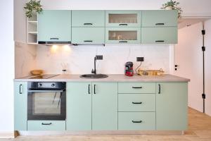 a kitchen with white cabinets and a sink at Infinity Breezes Apartment Beach Resort - parking in Mamaia