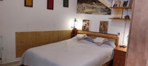 - une chambre avec un lit blanc et une tête de lit en bois dans l'établissement Spring apartment Bahar nissim Jerusalem, à Jérusalem