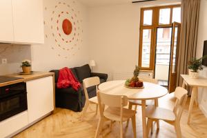 a kitchen and a living room with a table and chairs at Apartament Noc i Dzień in Toruń