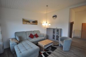 a living room with a couch and a table at Nr 201 - Ferienhaus Am Tief in Neuharlingersiel