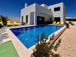 a villa with a swimming pool in front of a house at Villa Sonata in Ingrina Sol in Raposeira