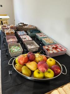 une table remplie de nombreux fruits et de paniers de nourriture dans l'établissement Hotel A Ladela, à O Vicedo