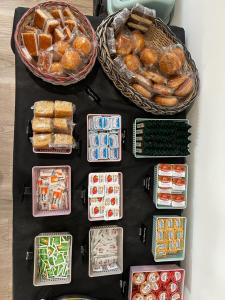 a table topped with baskets of bread and pastries at Hotel A Ladela in O Vicedo