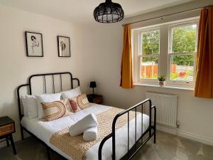a bedroom with a bed with pillows and a window at Stylish Central Reading Apartment - Free Parking in Reading