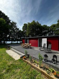 Przystanek Krąg في كرونغ: منزل احمر مع سطح مع طاولة وكراسي