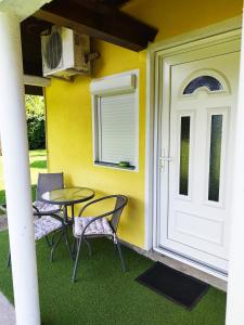 un patio con mesa y sillas junto a una puerta en Soba Milica en Palić