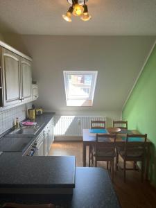 eine Küche mit einem Tisch und Stühlen sowie einem Fenster in der Unterkunft Appartments Endler in Bad Schandau