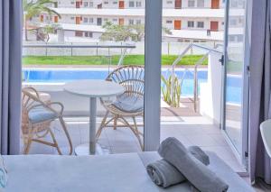 a room with a balcony with a table and chairs at Coral Ocean View - Adults Only in Playa de las Americas