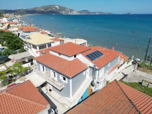 a group of houses with red roofs and the ocean at C'est La Vie Rooms and Suites in Laganas