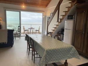 uma cozinha e sala de jantar com uma mesa e uma escada em Appartement Noirmoutier-en-l'Île, 1 pièce, 4 personnes - FR-1-224B-527 em Noirmoutier-en-l'lle