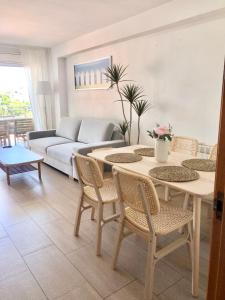 uma sala de estar com uma mesa e cadeiras e um sofá em Apartamento familiar con piscina y ubicación ideal em Platja d'Aro