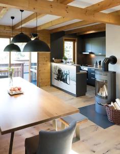 a kitchen with a wooden table and a dining room at MarktlAlm - Superior Waldblick Chalet mit Sauna in Turracher Hohe
