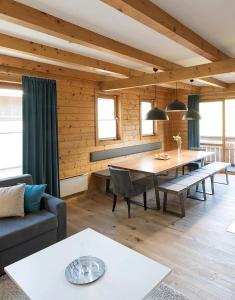 a living room with a table and a couch at MarktlAlm - Superior Waldblick Chalet mit Sauna in Turracher Hohe