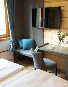 a room with a desk and a chair and a tv at MarktlAlm - Superior Waldblick Chalet mit Sauna in Turracher Hohe