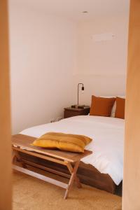 1 dormitorio con 1 cama con sábanas y almohadas blancas en Just Like Home Casa da Maria Olívia, en Paredes de Coura
