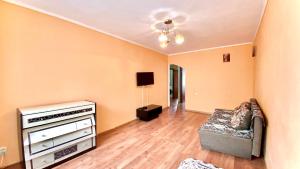 a living room with a couch and a television at МАДРИД Апартаменты 2-ком в центре in Petropavlovsk