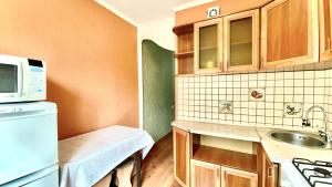 a small kitchen with a sink and a microwave at МАДРИД Апартаменты 2-ком в центре in Petropavlovsk +5 photos