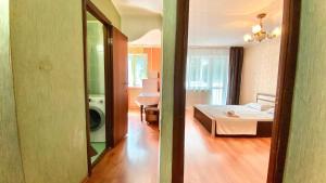 a bedroom with a bed and a room with a mirror at МАДРИД Апартаменты 2-ком в центре in Petropavlovsk