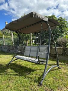 a bench with a canopy sitting in the grass at Villa Paxariño in Vilagarcia de Arousa