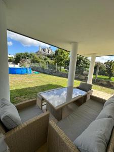 a patio with a table and chairs and a view of a yard at Villa Paxariño in Vilagarcia de Arousa