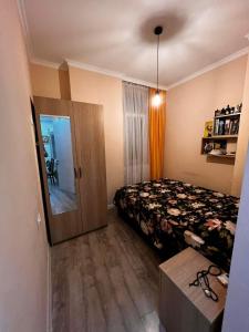 una piccola camera con letto e specchio di LIGHT HOUSE a Batumi