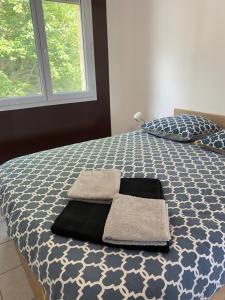 a bedroom with a bed with two towels on it at Grande maison récente avec vue in Saint-Hilaire