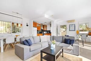 a living room with a couch and a table at Villa KIP, private pool & jacuzzi surrounded by nature in Pinar de Campoverde