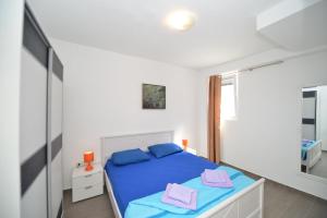 a bedroom with a blue bed and a mirror at Mystras Apartments in Kotor