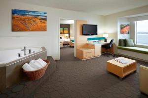 a hotel room with a tub and a desk and a television at Delta Hotels by Marriott Prince Edward in Charlottetown