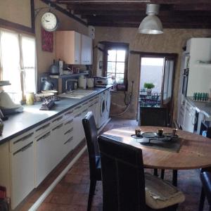 cocina con mesa de madera, mesa y sillas en Les chambres du vieux quartier, en Thouars