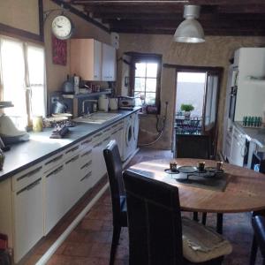 a kitchen with a wooden table and a table and chairs at Les chambres du vieux quartier in Thouars