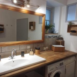 W łazience znajduje się umywalka i lustro. w obiekcie Les chambres du vieux quartier w mieście Thouars