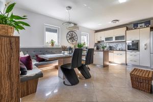 a kitchen and living room with a table and chairs at Vineyard Cottage Deer's Hill - Happy Rentals in Smarjeske Toplice