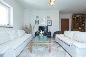 a living room with white couches and a coffee table at Houseloft Kalamaria Highview in Thessaloniki +22 photos