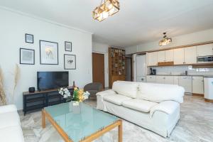 a living room with a white couch and a table at Houseloft Kalamaria Highview in Thessaloniki