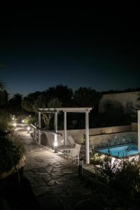 a pool at night with a pergola and a swimming pool at Annio studios in Plaka