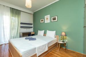 ein Schlafzimmer mit einem großen Bett mit blauer Wand in der Unterkunft Houseloft Kalamaria Highview in Thessaloniki