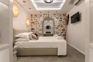 sypialnia z łóżkiem i kamienną ścianą w obiekcie Annio studios w mieście Plaka