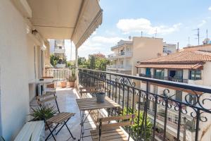 einen Balkon mit Stühlen und Tischen auf einem Gebäude in der Unterkunft Houseloft Kalamaria Highview in Thessaloniki