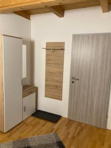 Una habitación con puerta y una habitación con techos de madera. en Fewo Waldheim, en Greifenburg