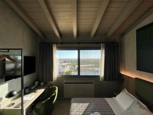 una camera d'albergo con un letto e una grande finestra di Terreforti Luxury Village a Agrigento