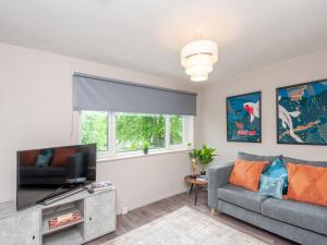 a living room with a couch and a tv at Pass the Keys Couples Haven Horsforth in Leeds