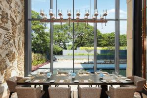 a dining room with a table with chairs and a large window at The Ritz-Carlton, Pune in Pune
