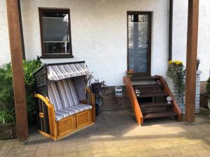 une terrasse couverte d'une maison avec un banc et une fenêtre dans l'établissement Ferienwohnung Eisenach Meyer, à Eisenach