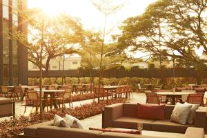 a patio with tables and chairs and the sun shining at The Ritz-Carlton, Pune in Pune