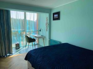 1 dormitorio con cama, escritorio y ventana en Roja apartment for family, en Roja