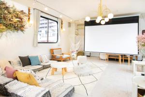 a living room with couches and a projection screen at Meee Asakusa3F4F 浅草徒歩3分 140平米Max22名 無料駐車場 屋上絶景 渋谷直通 in Tokyo