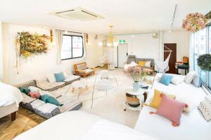 salon z białymi kanapami i kolorowymi poduszkami w obiekcie Meee Asakusa3F4F 浅草徒歩3分 140平米Max22名 無料駐車場 屋上絶景 渋谷直通 w Tokio