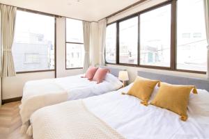 Łóżko lub łóżka w pokoju w obiekcie Meee Asakusa3F4F 浅草徒歩3分 140平米Max22名 無料駐車場 屋上絶景 渋谷直通