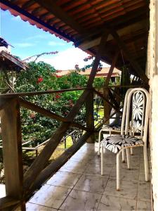two white chairs sitting on a porch at Falésias de Carapibus in Conde